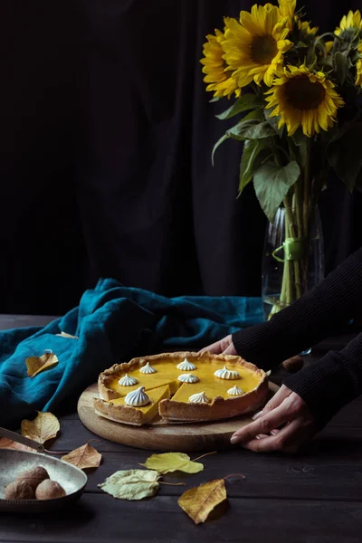 Mains féminines plaçant tarte sur la table — Photo de stock