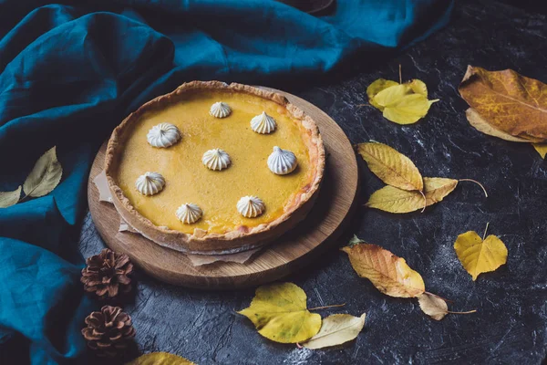 Pumpkin pie on wooden chopping block — Stock Photo