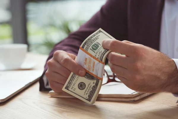 Бізнесмен тримає доларові банкноти — стокове фото