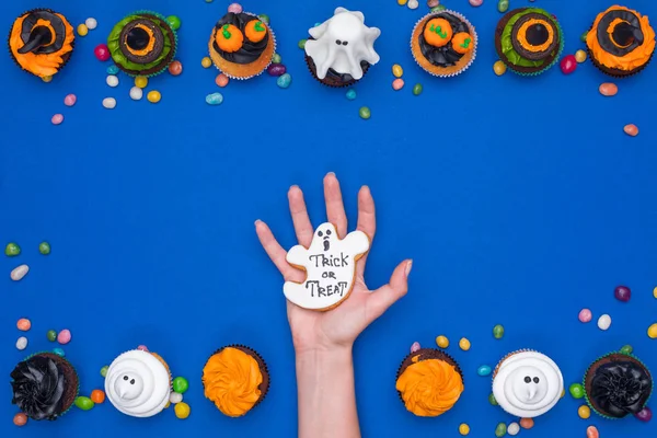 Hand and halloween cupcakes — Stock Photo