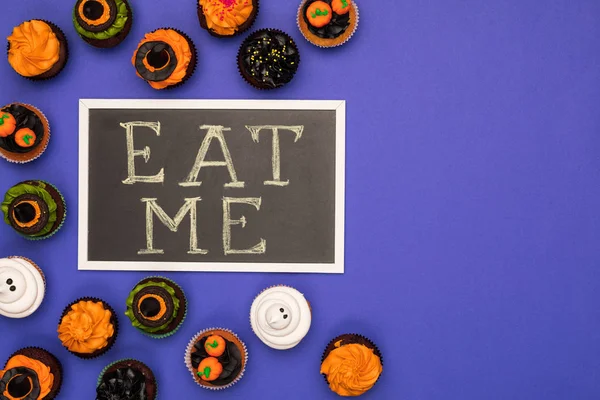 Halloween cupcakes and eat me inscription — Stock Photo