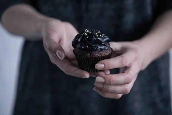 Manos celebración de Halloween cupcake - foto de stock