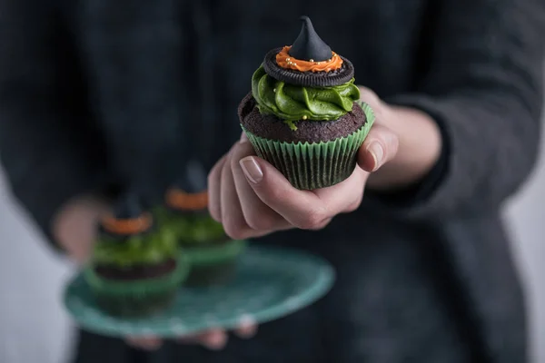 Person holding halloween cupcake — Stock Photo