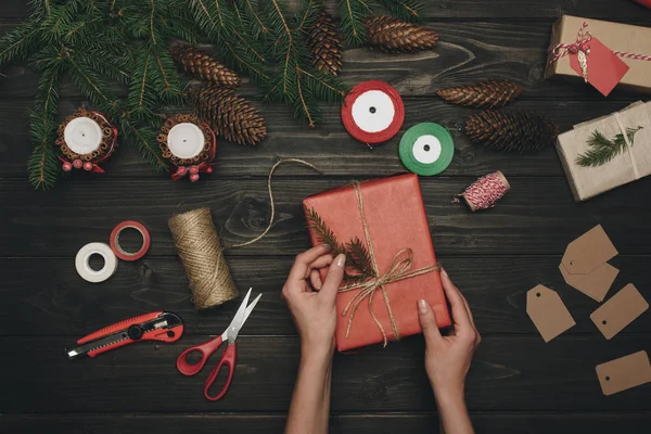 Woman decorating christmas gift — Stock Photo