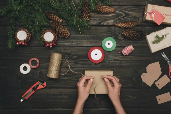 Woman decorating christmas gift — Stock Photo