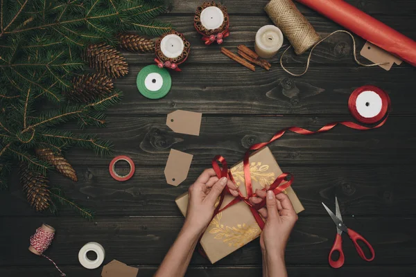Woman decorating christmas gift — Stock Photo
