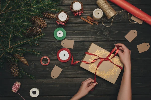 Woman decorating christmas gift — Stock Photo