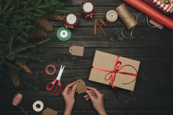 Woman decorating christmas gift — Stock Photo