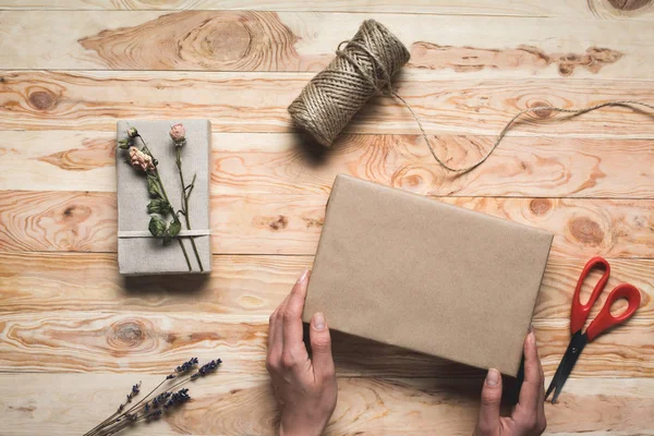 Woman decorating christmas gift — Stock Photo