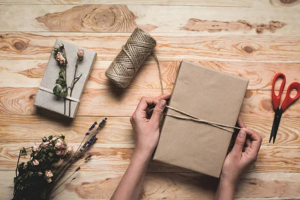 Woman decorating christmas gift — Stock Photo