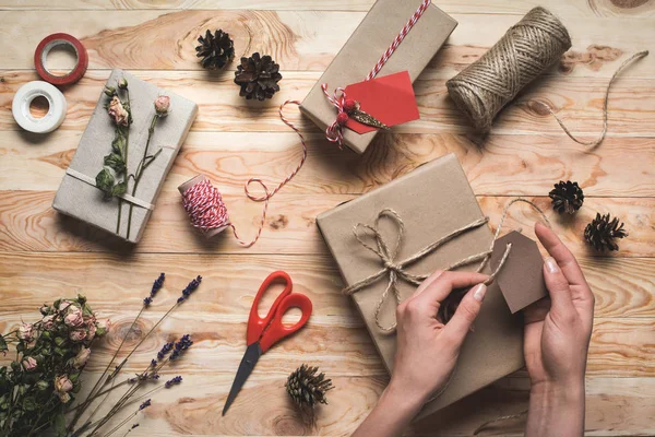 Woman decorating christmas gift — Stock Photo