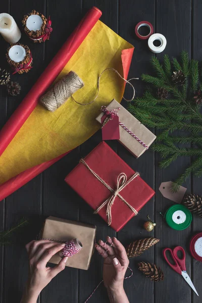 Жінка прикрашає різдвяні подарунки — стокове фото