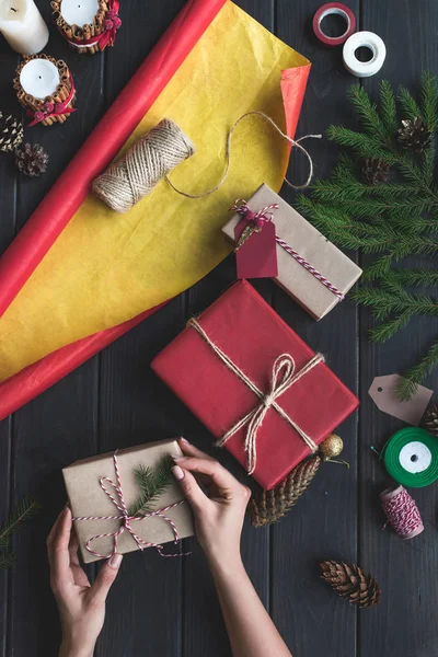 Woman decorating christmas gifts — Stock Photo