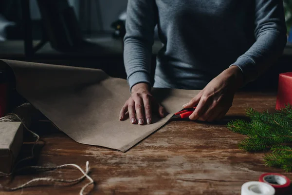 Женщина режет крафт бумаги — стоковое фото