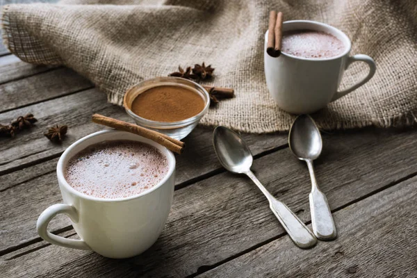 Cups of cacao and spices on table — Stock Photo