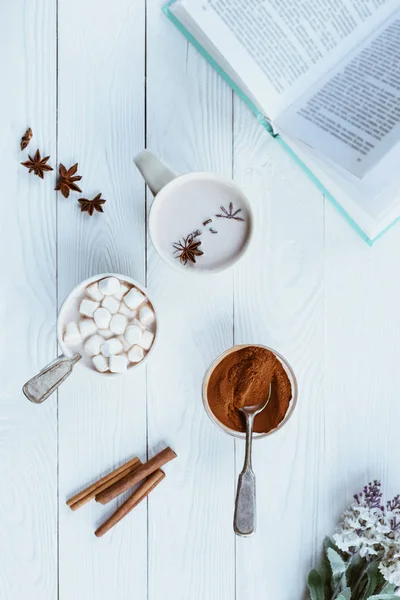 Tazas de cacao aromático y libro - foto de stock