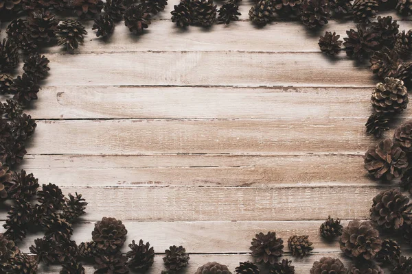 Cônes de pin sur la surface en bois — Photo de stock