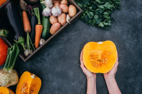 Citrouille coupée en deux dans les mains — Photo de stock