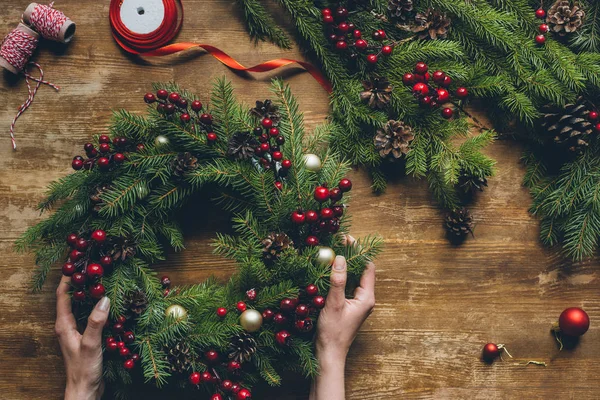Hands holding Christmas wreath — Stock Photo