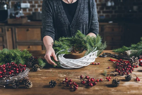 Florist making Christmas wreath — Stock Photo