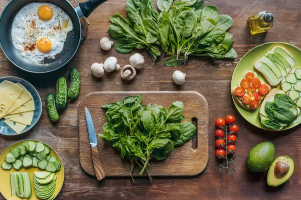 Espinacas y cuchillo en la tabla de cortar - foto de stock