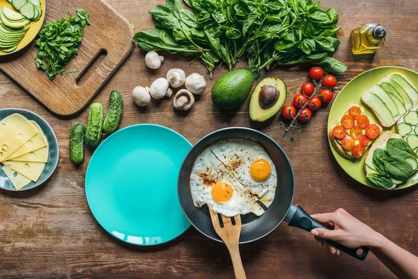 Frau serviert Spiegeleier zum Frühstück — Stockfoto