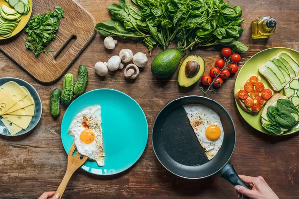 Woman serving fried eggs for breakfast — Stock Photo