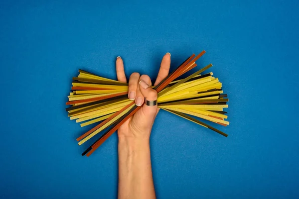 Woman holding raw spaghetti — Stock Photo