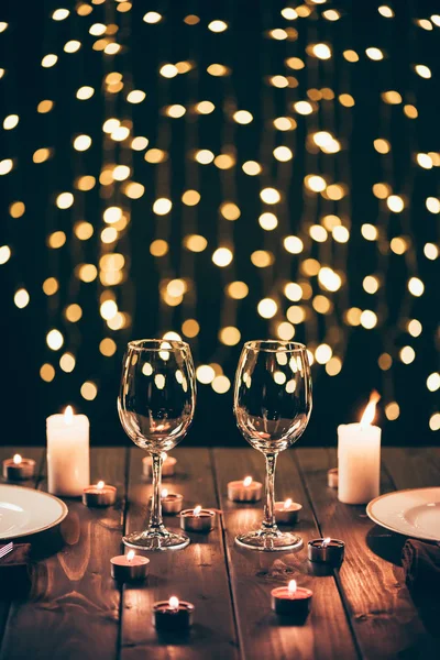 Wineglasses on table with candles — Stock Photo