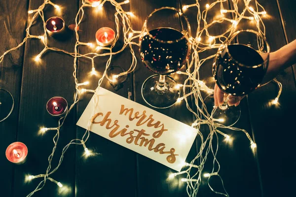 Glasses with wine and merry christmas card — Stock Photo