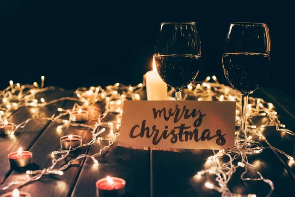 Glasses with wine and merry christmas card — Stock Photo