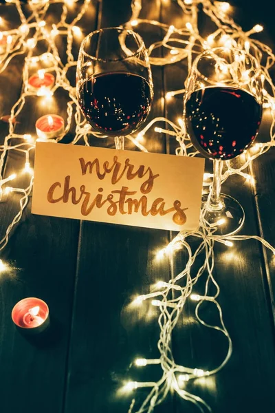 Wineglasses and merry christmas card — Stock Photo