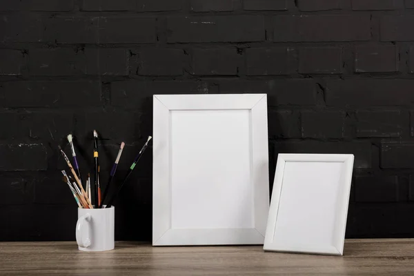 Photo frames and drawing equipment on table — Stock Photo