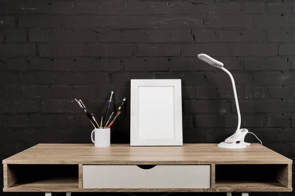 Cadre photo et lampe de table sur le lieu de travail — Photo de stock