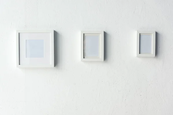 Empty photo frames hanging on wall — Stock Photo