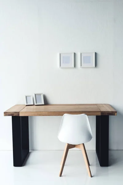 Photo frames hanging on wall at workplace — Stock Photo