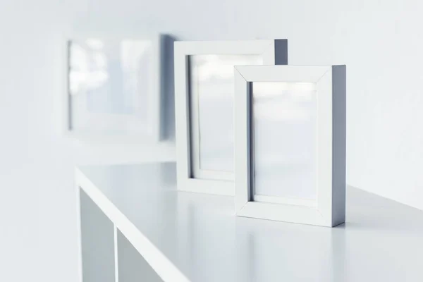 Empty photo frames on bookshelf — Stock Photo