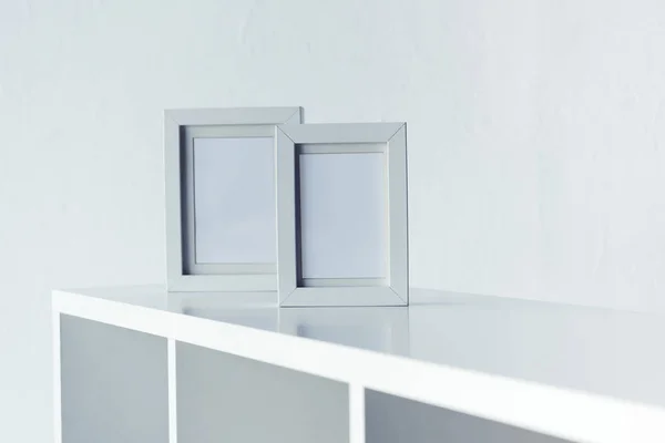 Empty photo frames on bookshelf — Stock Photo