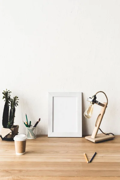 Photo frame and coffee to go on table — Stock Photo