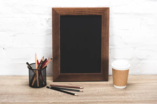 Photo frame and coffee to go on table — Stock Photo