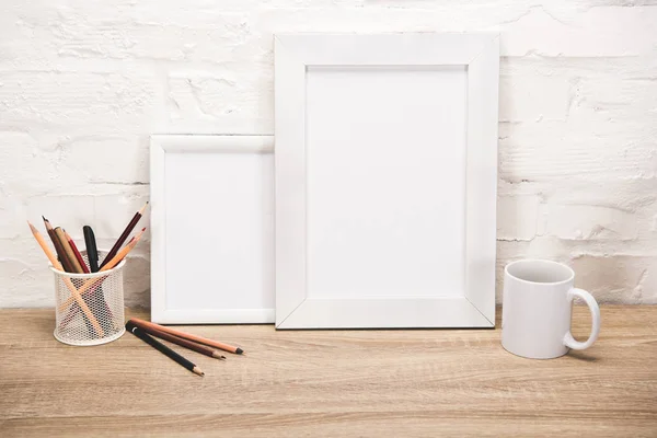 Photo frames and coffee cup on tabletop — Stock Photo