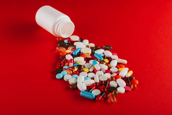 Colorful pills and container — Stock Photo