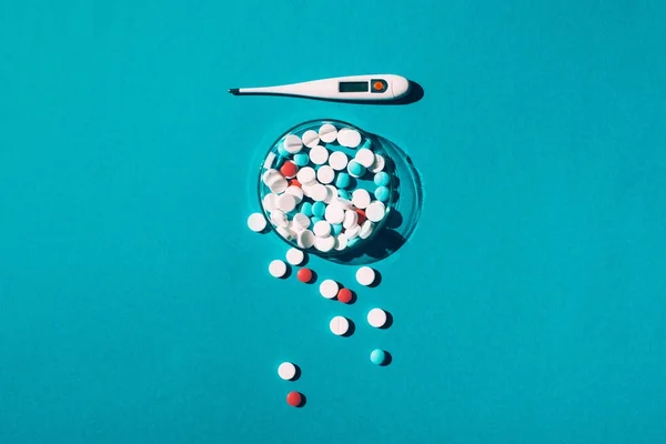 Colorful pills and thermometer — Stock Photo