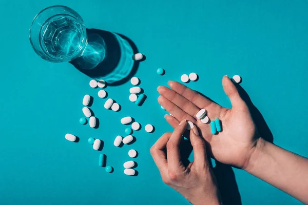Pills in hands and water in glass — Stock Photo
