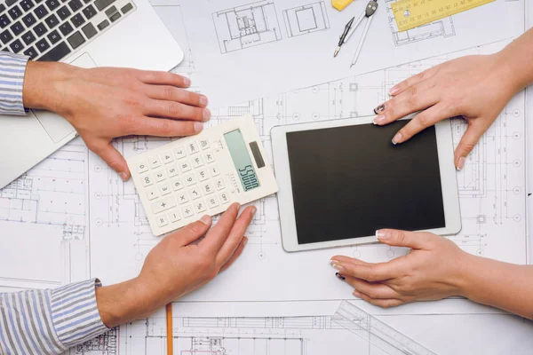 Arquitectos en el lugar de trabajo con planos - foto de stock