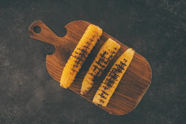 Maíz a la parrilla en tabla de cortar de madera - foto de stock