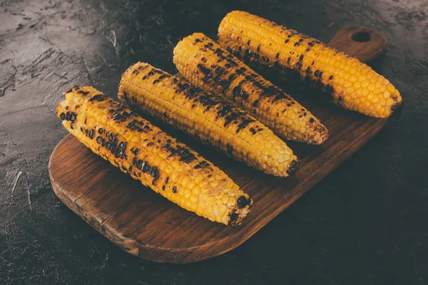 Grilled corn on cutting board — Stock Photo