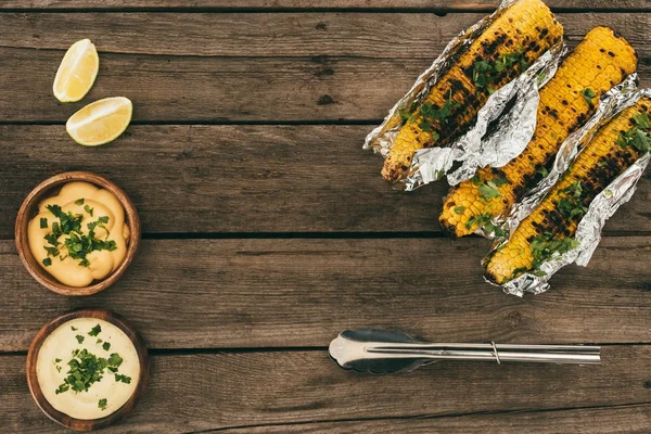 Maíz a la parrilla sobre mesa de madera - foto de stock