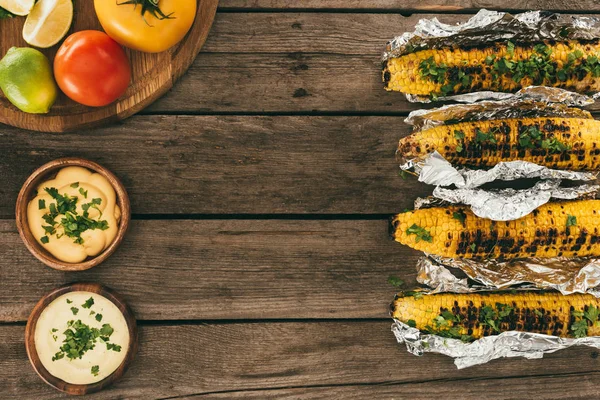 Grilled corn on wooden table — Stock Photo