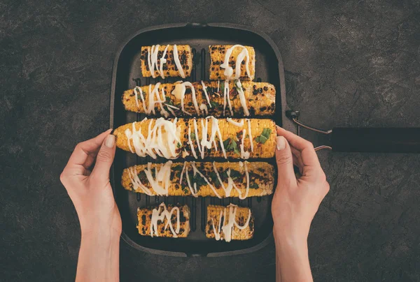 Mujer con bandeja para hornear de maíz - foto de stock